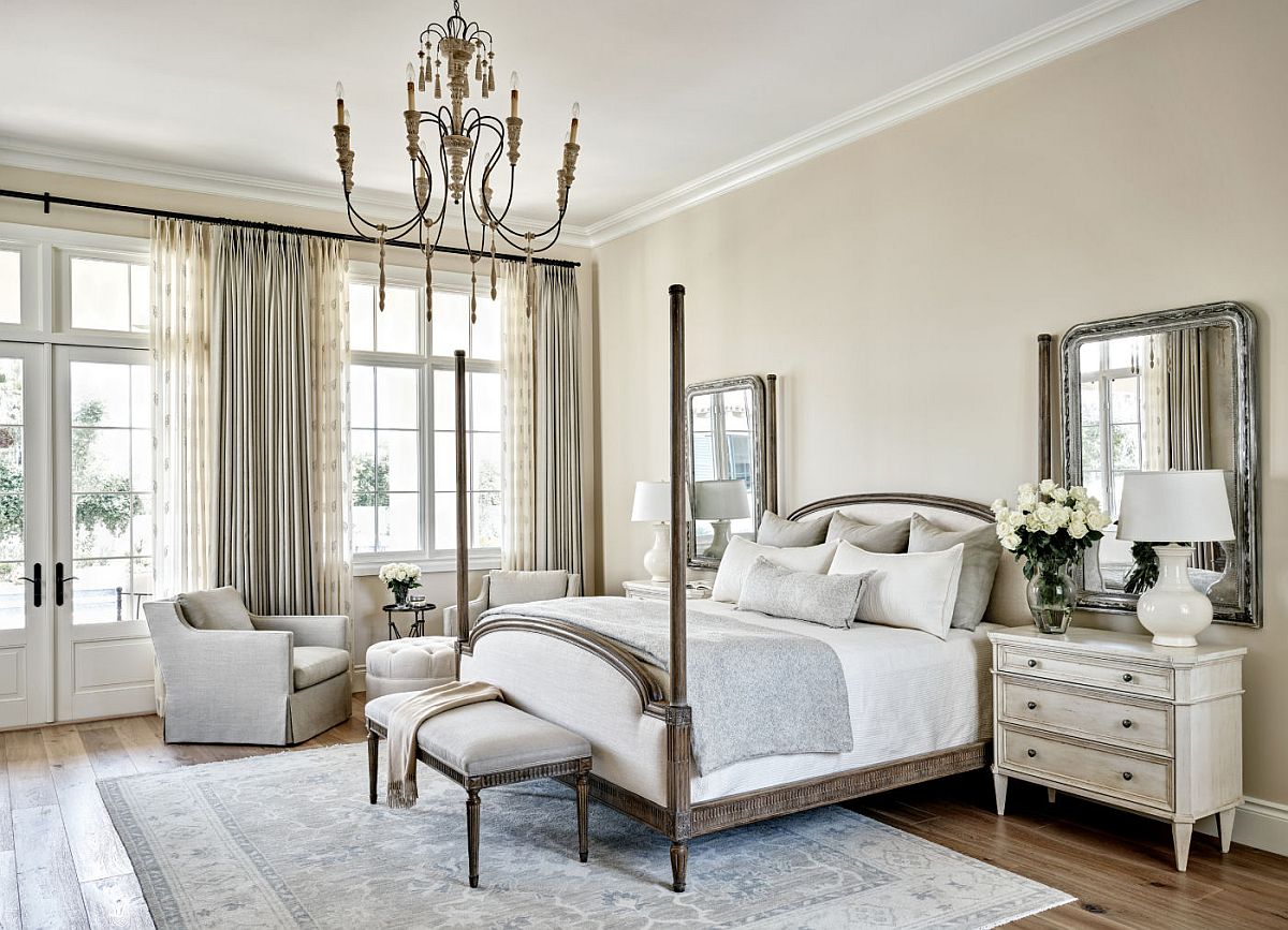 Transitional bedroom in white with mirrors above the nightstand that bring symmetry to the interior