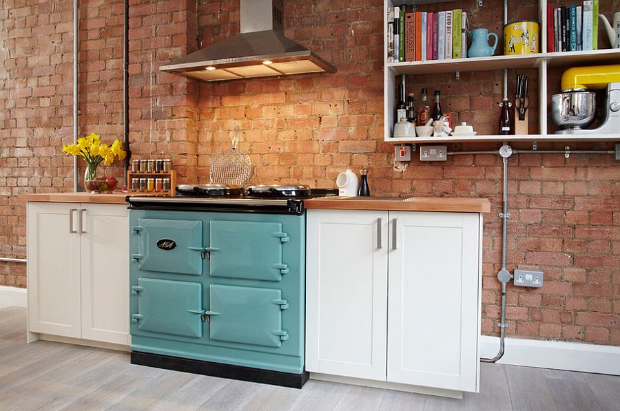 Wall-mounted shelves and clever cabinets give the small industrial kitchen with exposed brick wall a more organized look