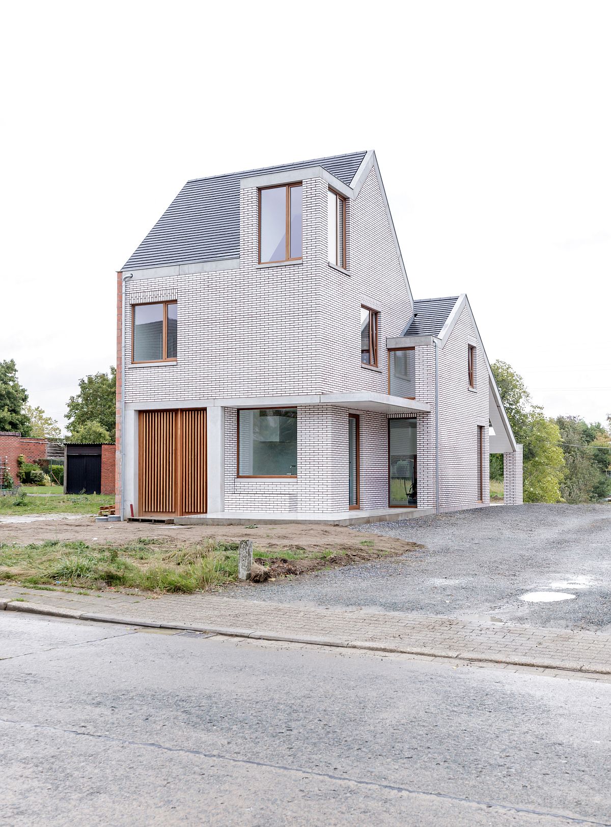 Wooden door and frames of the house give contrast to the facade of the house