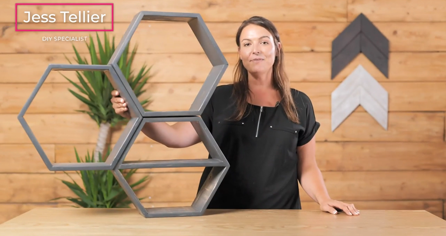woman holding three completed hexagon shelves