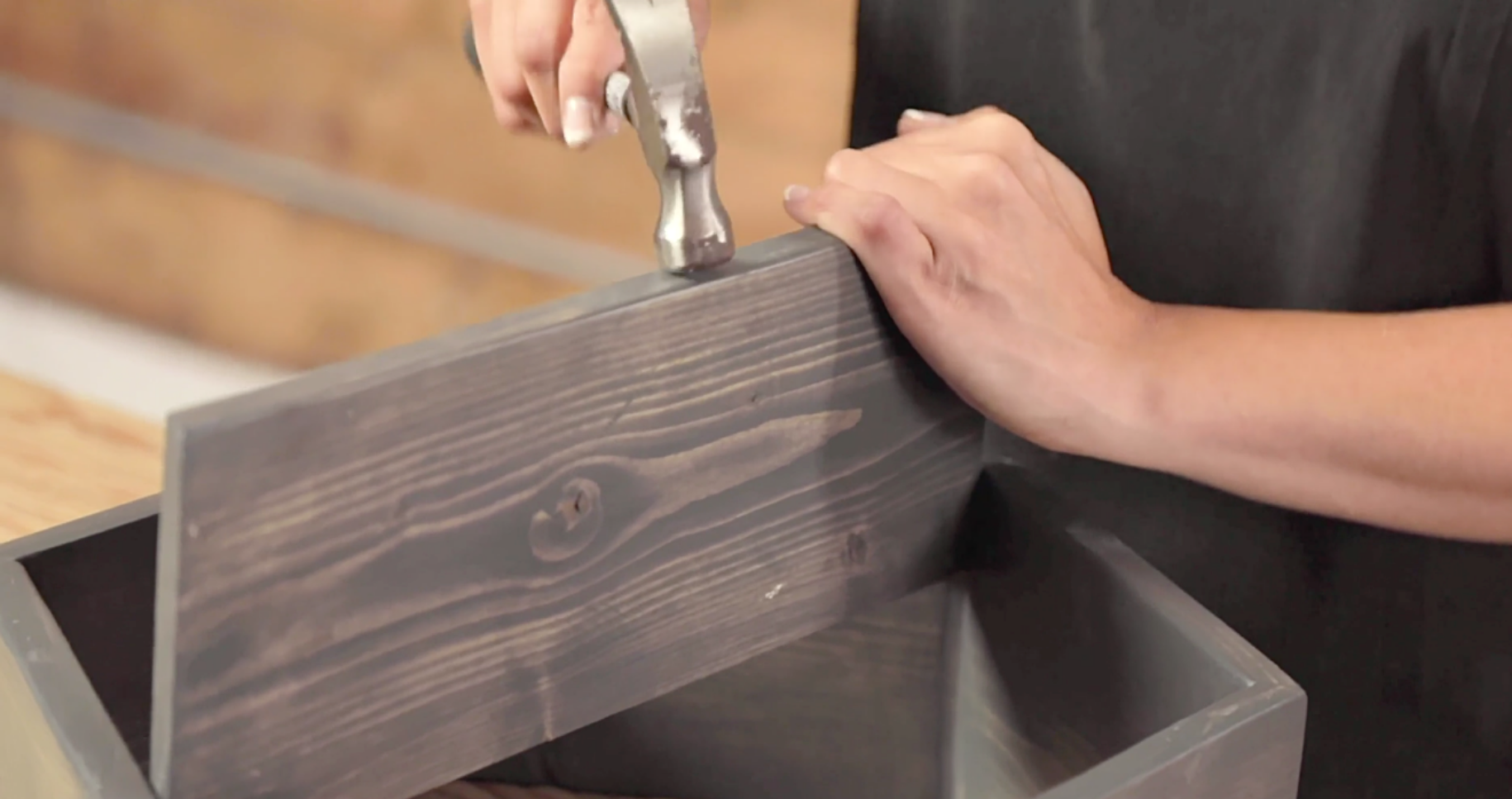 woman hammers shelf into hexagon box