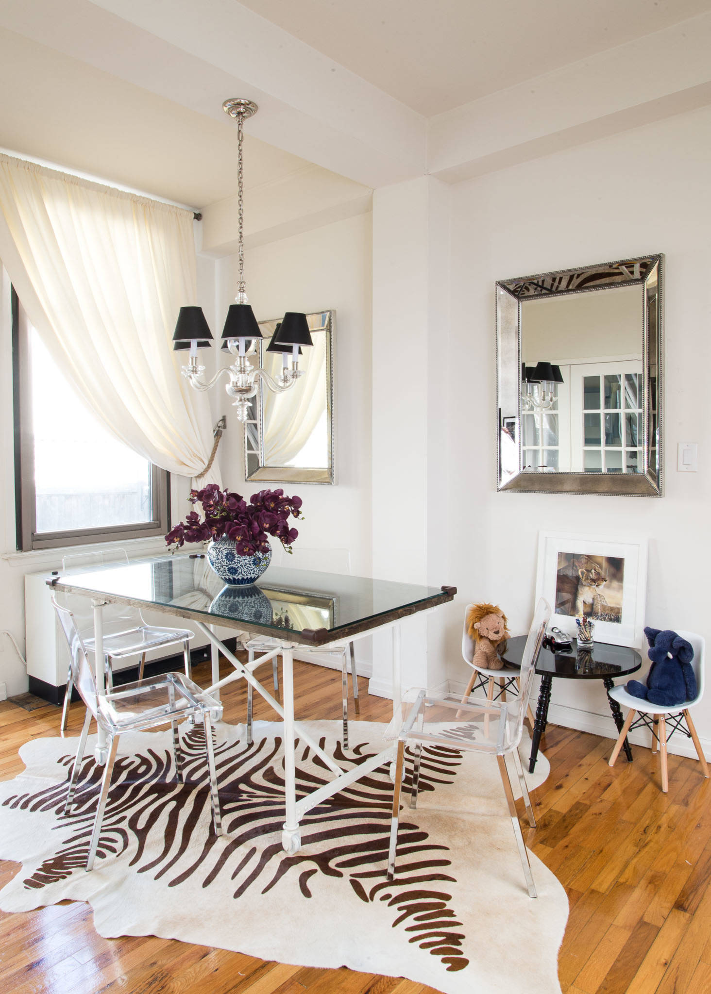 Acrylic chairs, mirrors and the white backdrop create a breezy, beautiful dining room that is spacious despite its small size