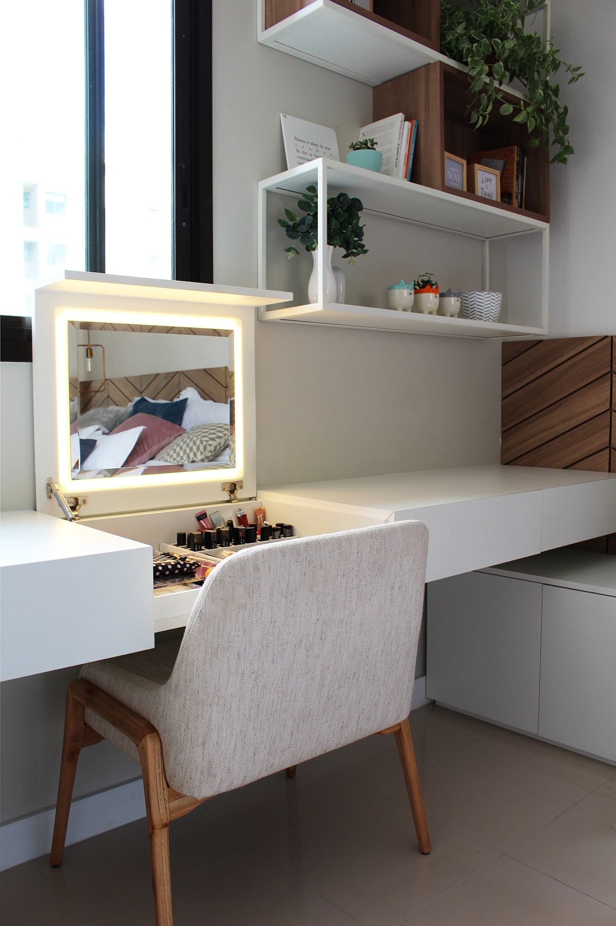 Bedroom study space along with storage units for beauty accessories and a space-savvy mirror