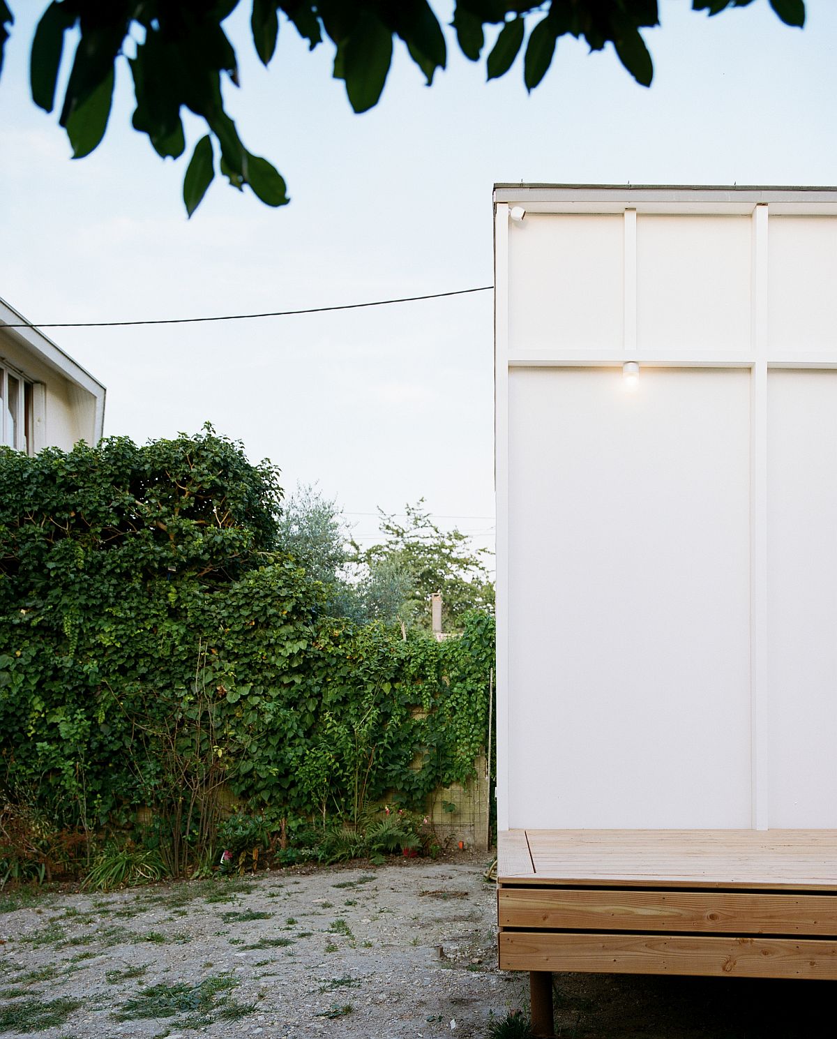 Box-styled rear extension of aging French home on an elevated wooden platform