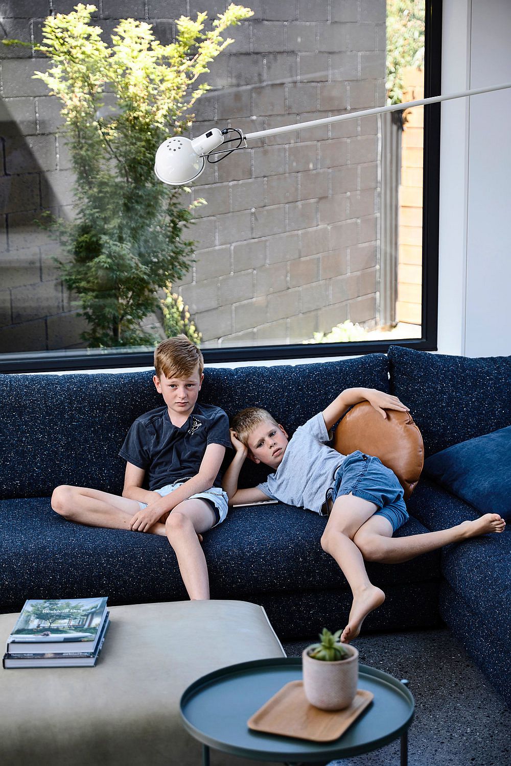 Comfy dark blue sectional in the living room along with smart sconce light