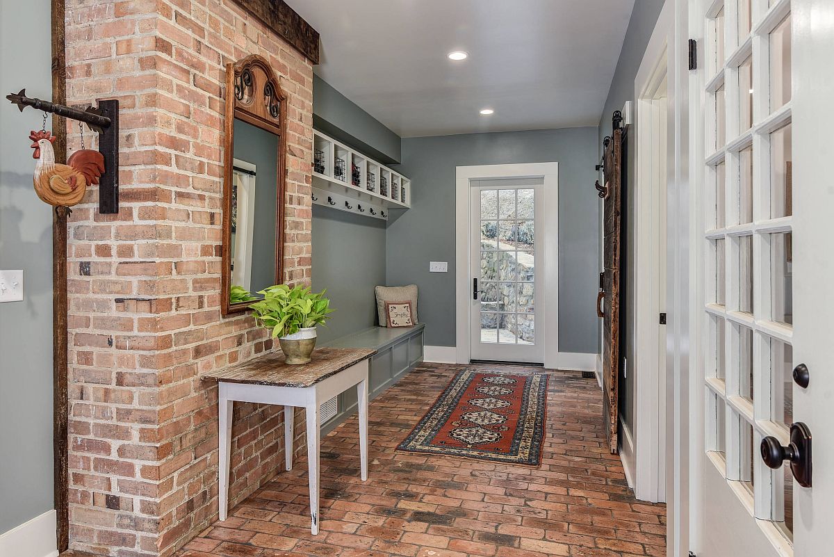 Contemporary and farmhouse styles combined effortlessly in the spacious entry with exposed brick and gray walls