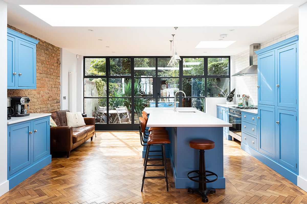 Contemporary kitchen with blue cabinets, smart island and exposed brick wall