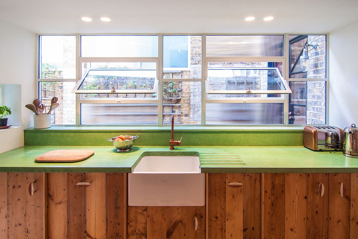 Custom green concrete countertop coupled with reclaimed wood cabinets in the kitchen