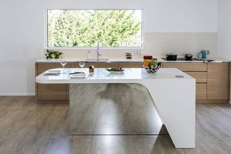 Custom kitchen island with a mirrored section and flowing form designed by Charlotte Raynaud and Menuiserie Hegenbart