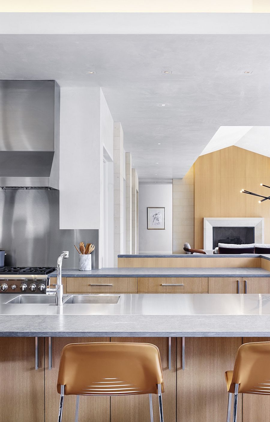 Dining area and kitchen of the renovated Texas home adopt a white and wood color scheme along with a dash of gray