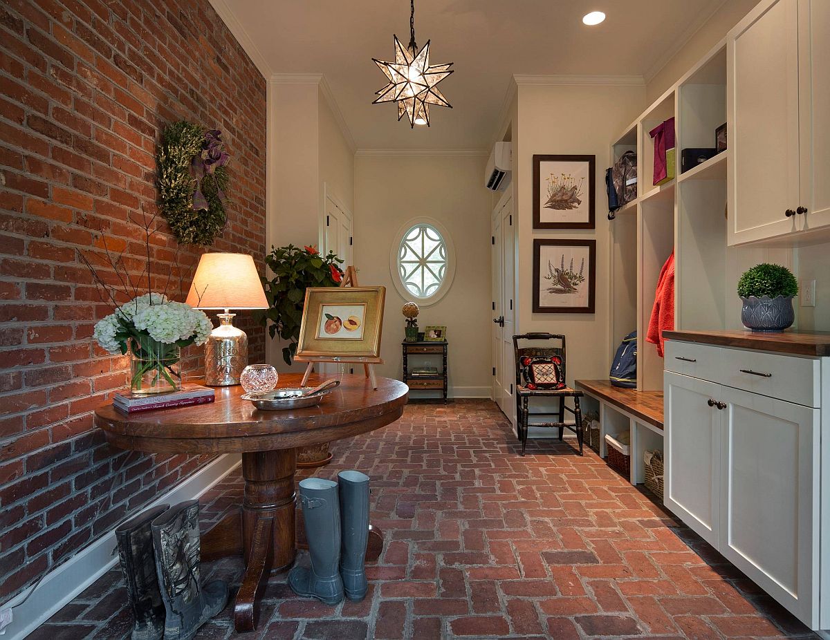 Exposed brick wall and brick floor give this spacious entryway an authentic farmhouse appeal