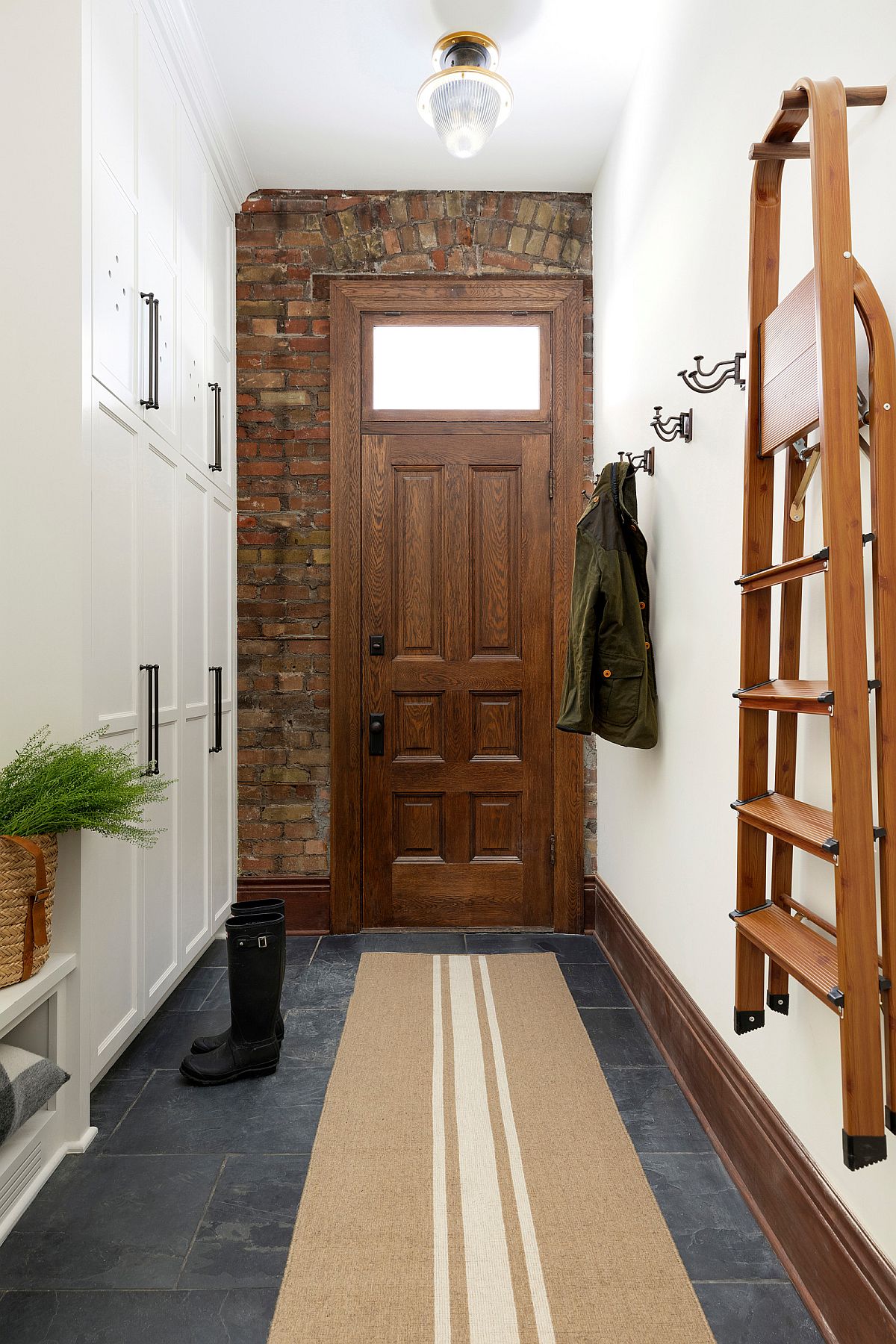 Exposed wall next to the main door brings that 'something different' to the small entryway