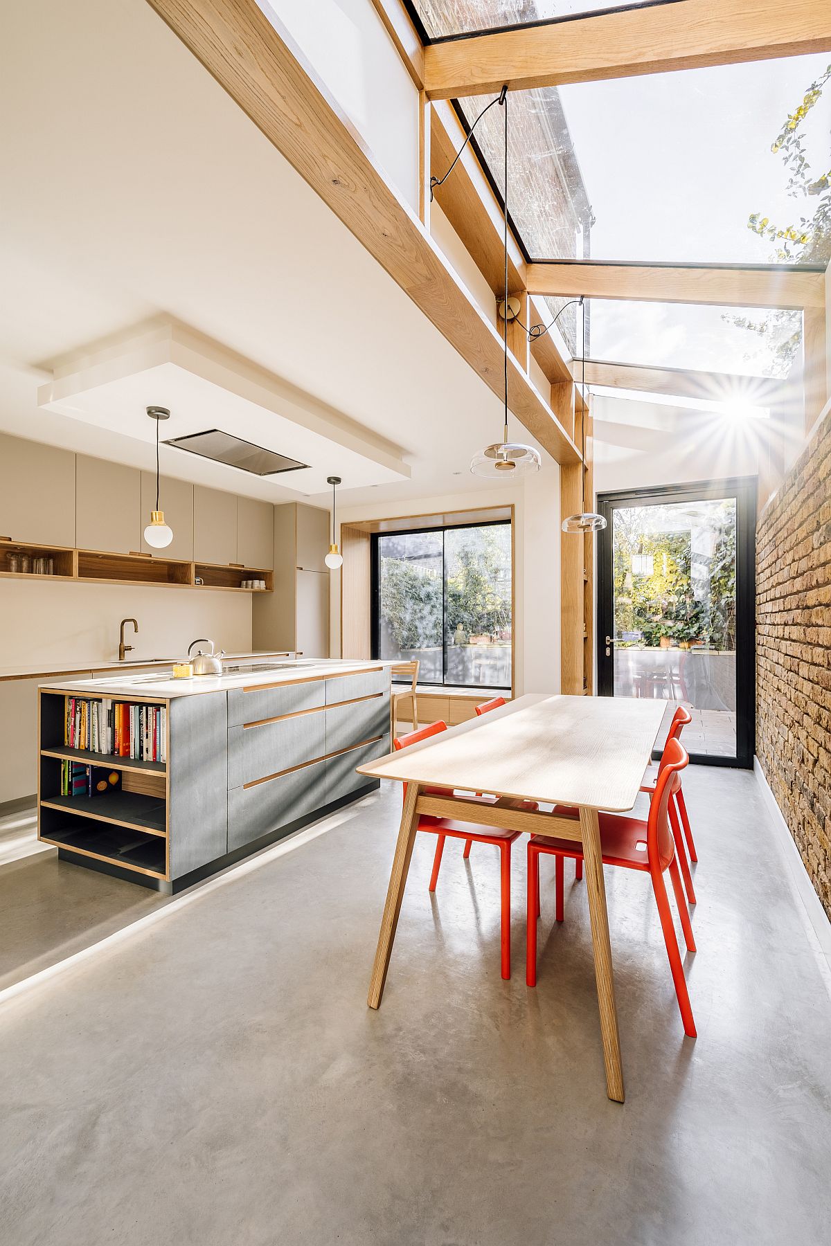 Exquisite modern kitchen with dining space is beautifully lit by the large sky light above