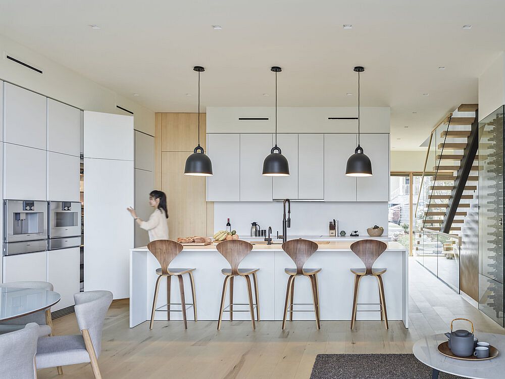 Functional modern kitchen in white and wood with dark pendant lights