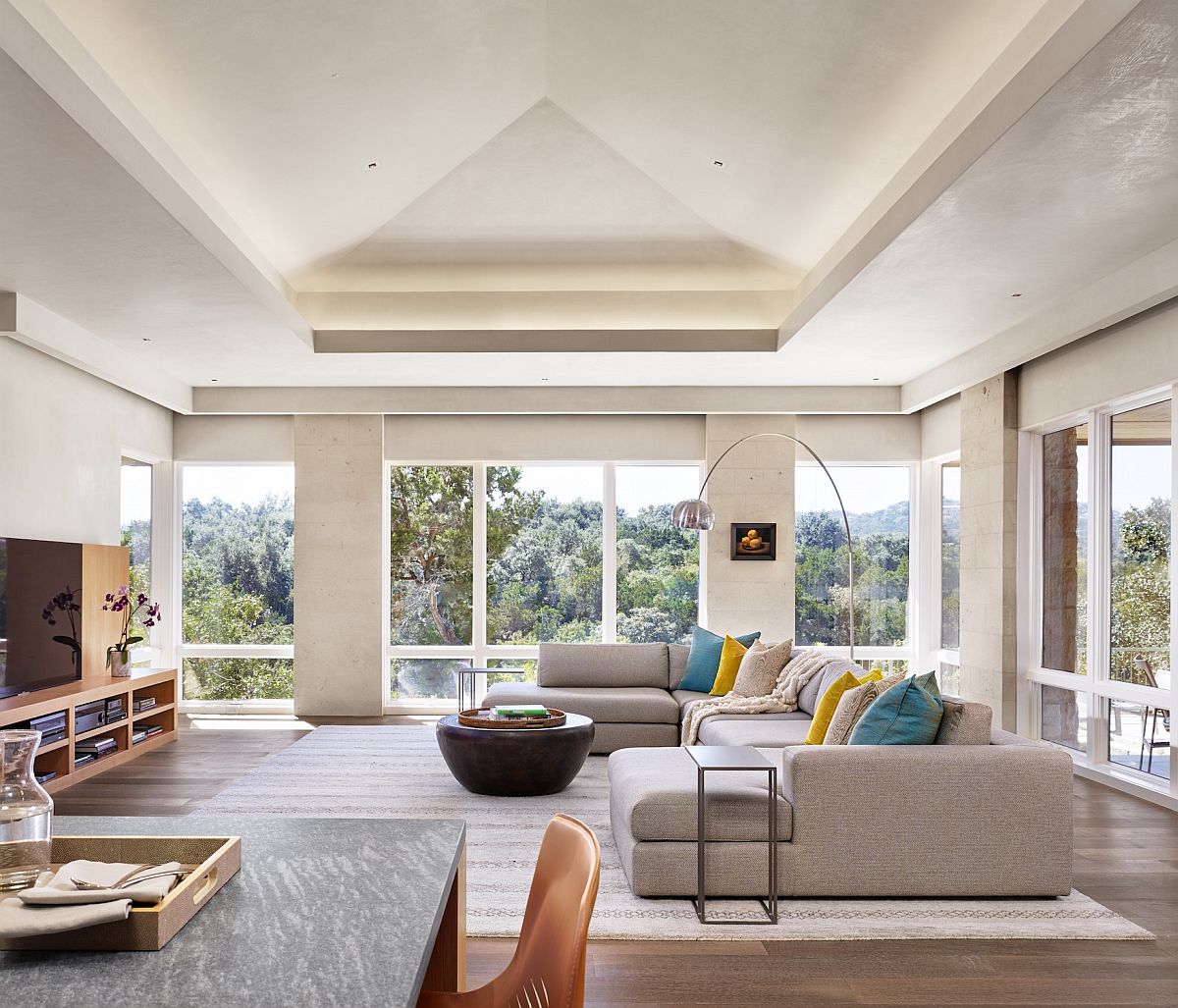 Modern minimal family room with a lovely view of the outdoors and a comfortable cozy sectional at its heart