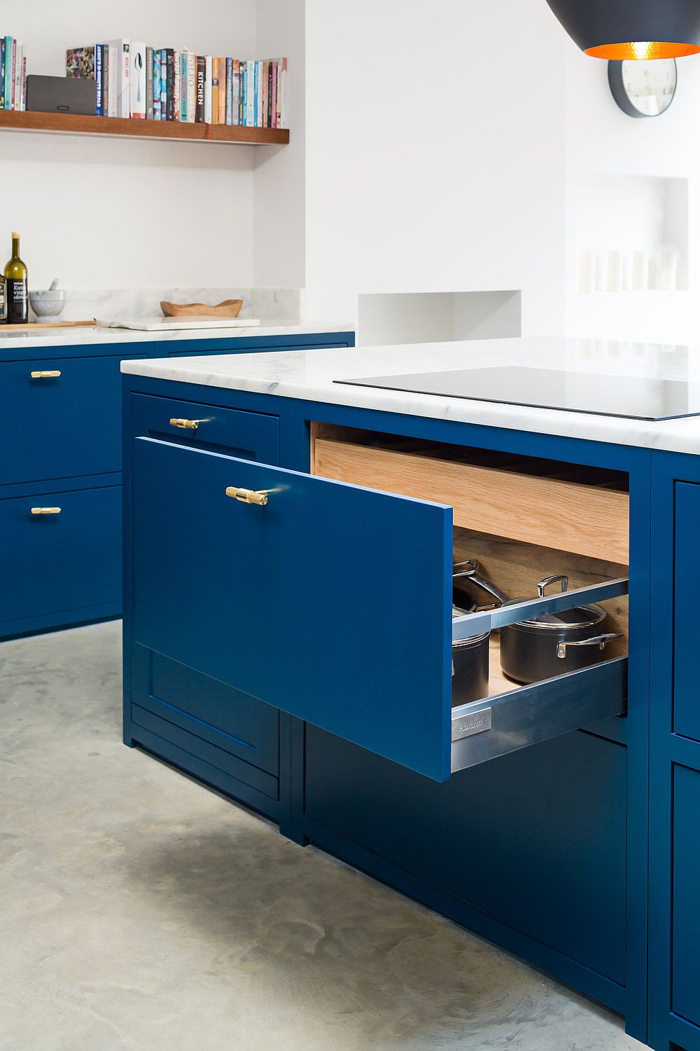 Oak internals and drawer inserts bring smart storage to the deep blue kitchen island