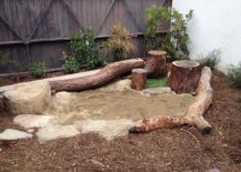 Rustic-backyard-play-area-with-a-sandbox-that-is-surrounded-by-tree-trunks-and-wooden-logs-94597-217x155