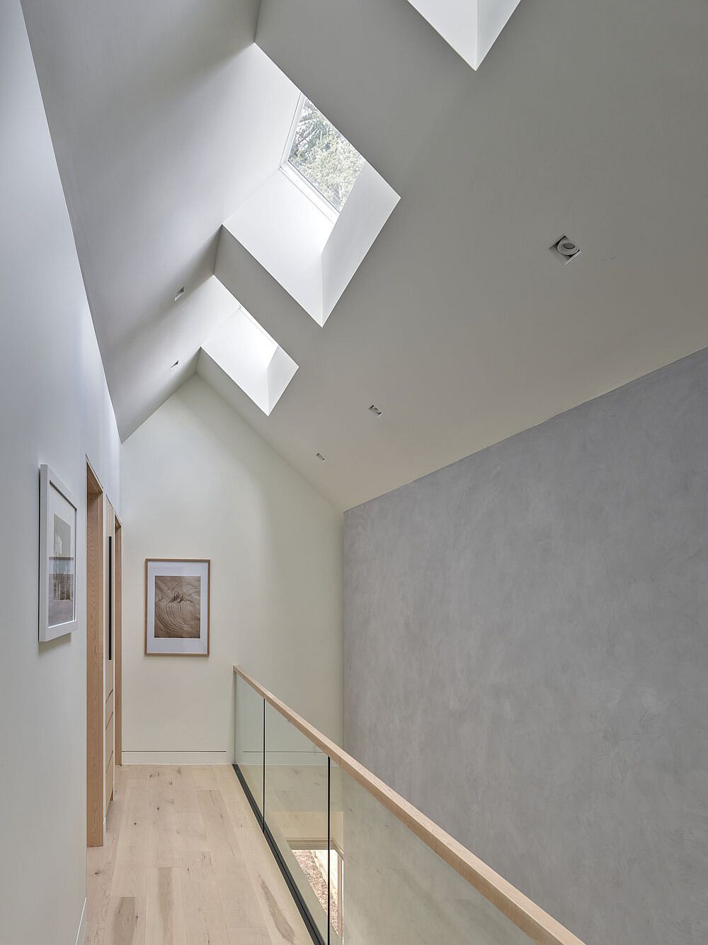 Series of skylights on the upper level bring ample natural light into the minimal, multi-level interior