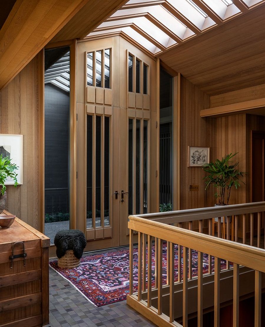 Skylight brings ample natural light into the home with high ceiling and wooden walls