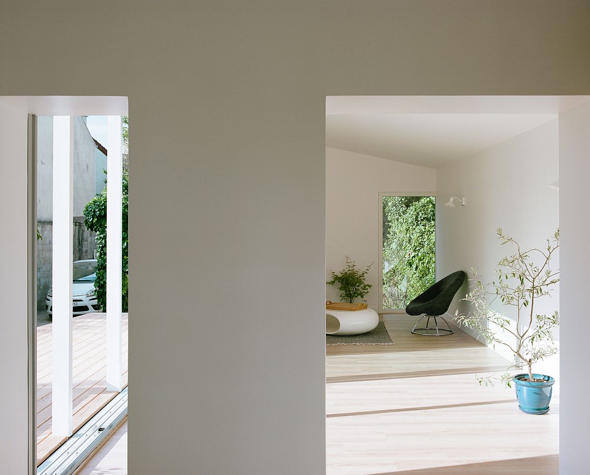 Sliding glass doors bring ample natural light into the white and wood interior of the home