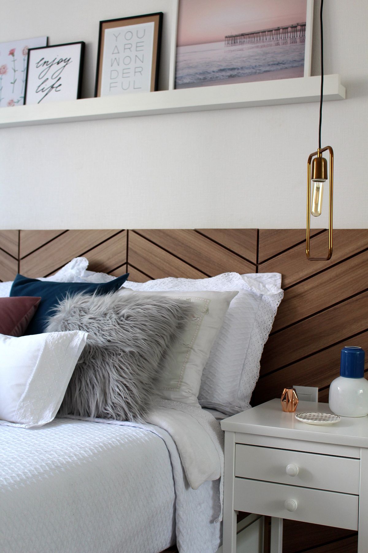 Slim bedside lighting with metallic glitz brings contrast to the modern wood and white bedroom