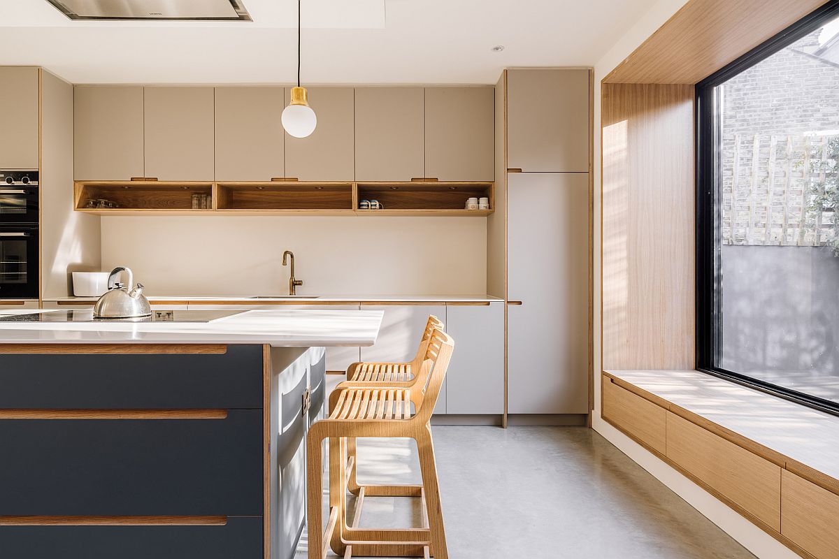 Smart rear extension of Victorian home in London with modern kitchen that has a bespoke window seat