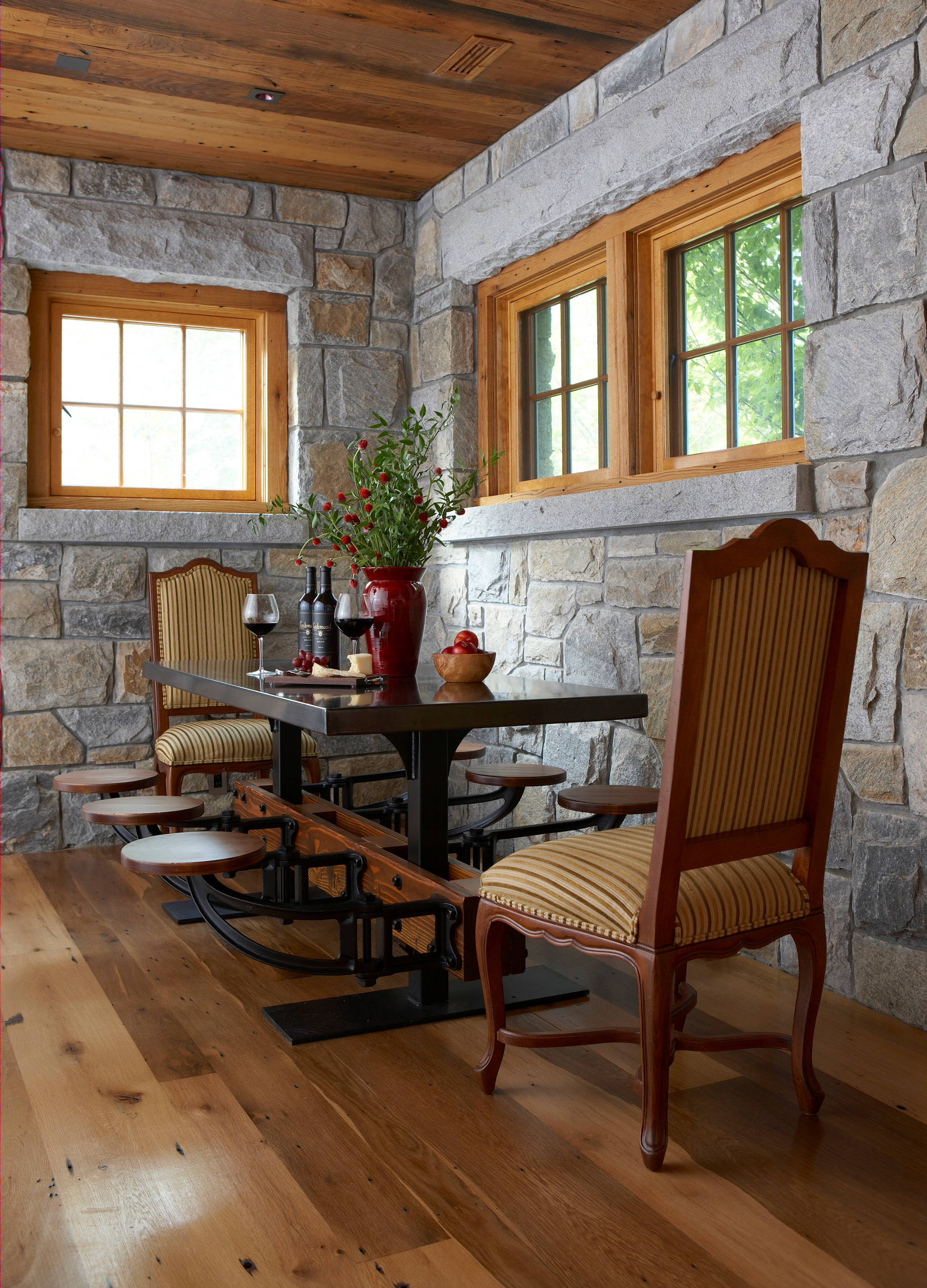 Stone walls and wooden ceiling give thi New York home dining room a more classical appeal