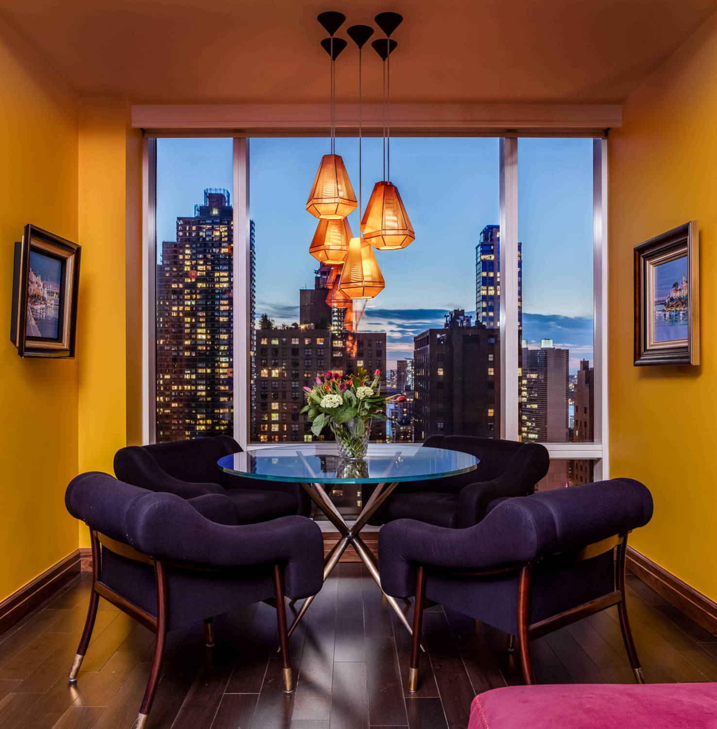 Stunningly beautiful dining room of apartment near Central Park in NYC with captivating views of the city and bright yellow walls