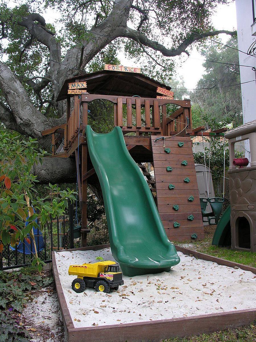 Treehouse built into an oak tree along with a slide and sandbox make for a dream backyard playarea