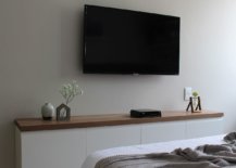 Wall-mounted-TV-in-the-bedroom-along-with-a-slim-storage-space-below-88649-217x155