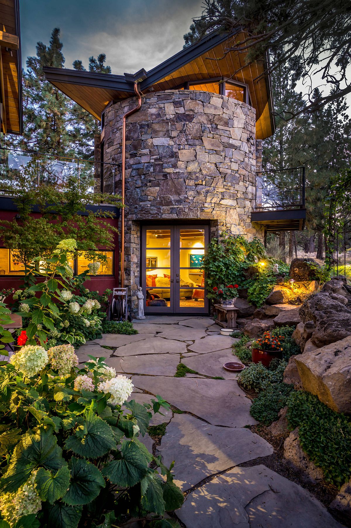 Curved stone wall plays into the overall narrative of the rustic landscape around the home