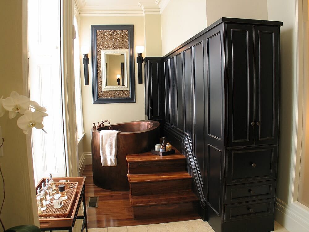 Custom wooden cabinet and steps combined with the space-savvy soaking tub