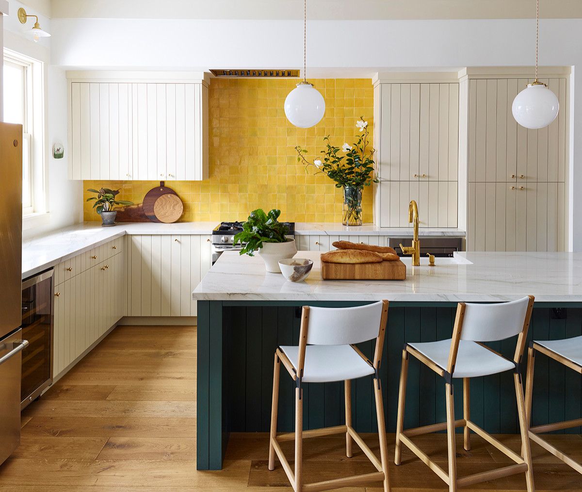 Dark green kitchen sialnd and a brilliant yellow backsplash for the chic farmhouse kitchen