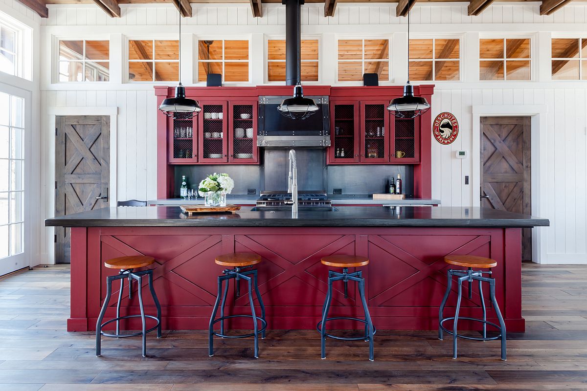 Dark red kitchen island along with cabinets shapes the backdrop of this farmhouse-industrial kitchen