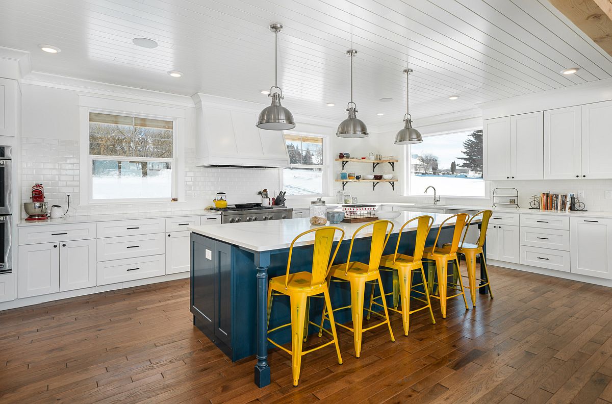 Dashing blue kitchen island coupled with dark yellow chairs makes a big visual impact in here