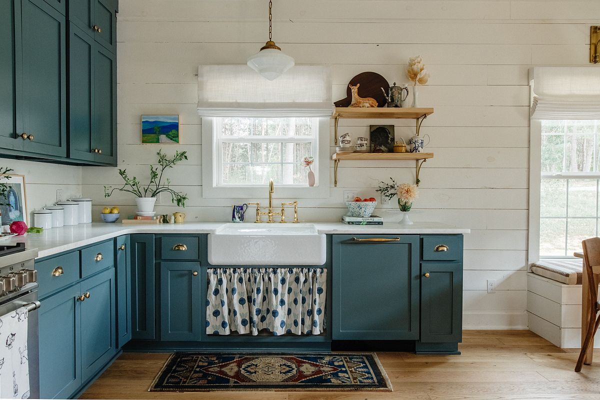 Gorgeous grayish blue cabinets along with brass handles bring bightness to this farmhouse style kitchen