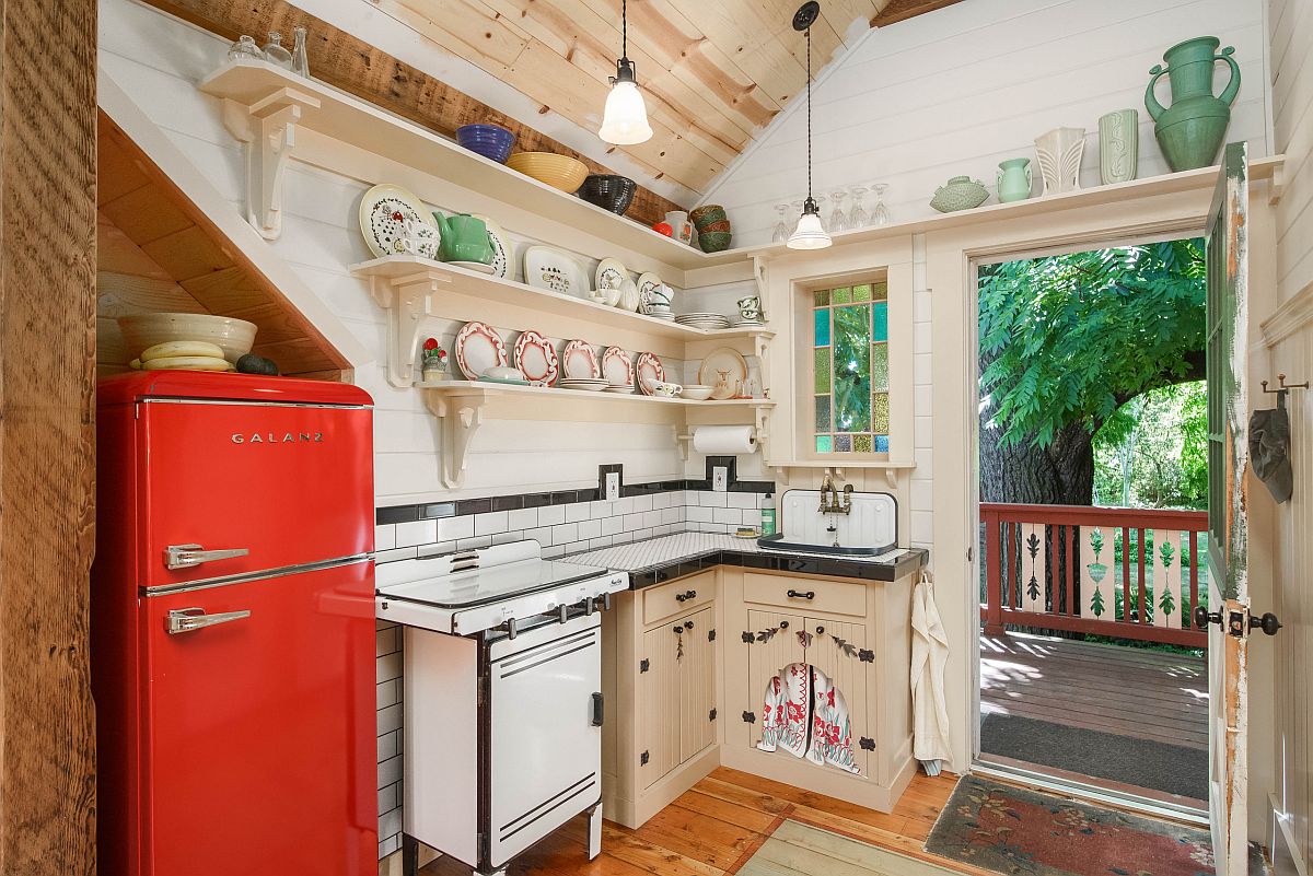 It is the vintage refigerator in red that brings color to this small farmhouse style kitchen in wood and white