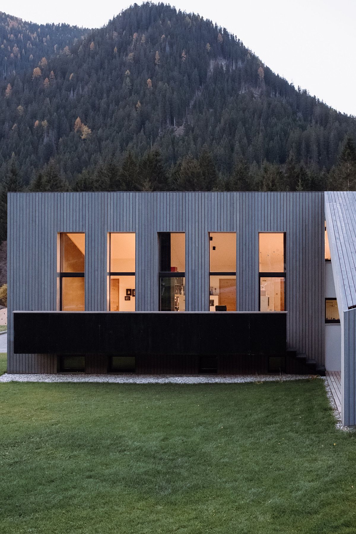 Lovely protected forests and mountains shape the backdrop of the L-shaped house