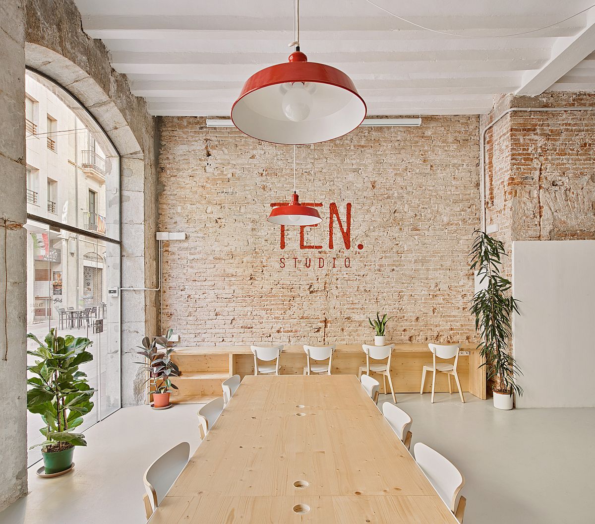 Office of TEN Studio in Spaing with white walls, ceiling and exposed brick sections