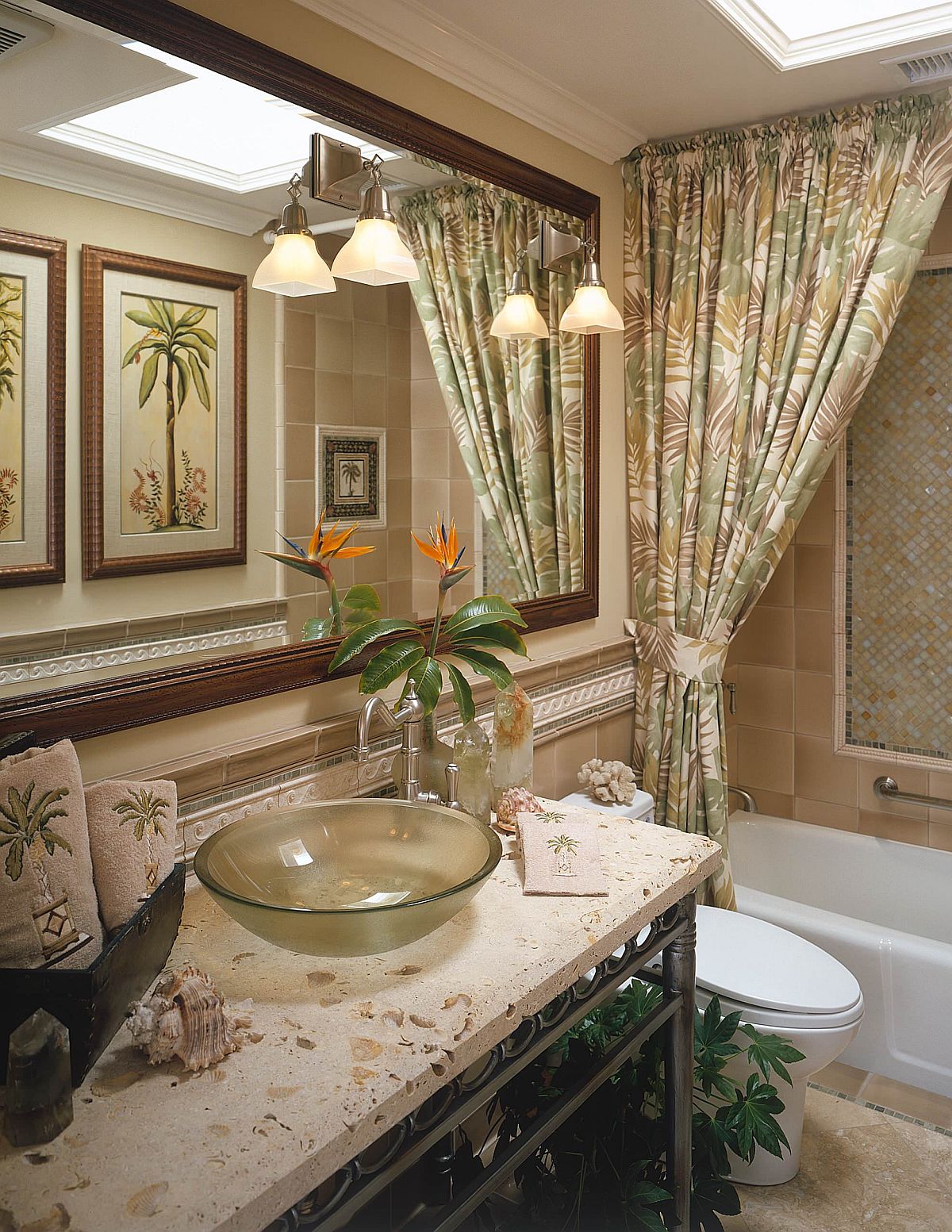 Pattern-filled tropical style bathroom in green with lovely sconce lights