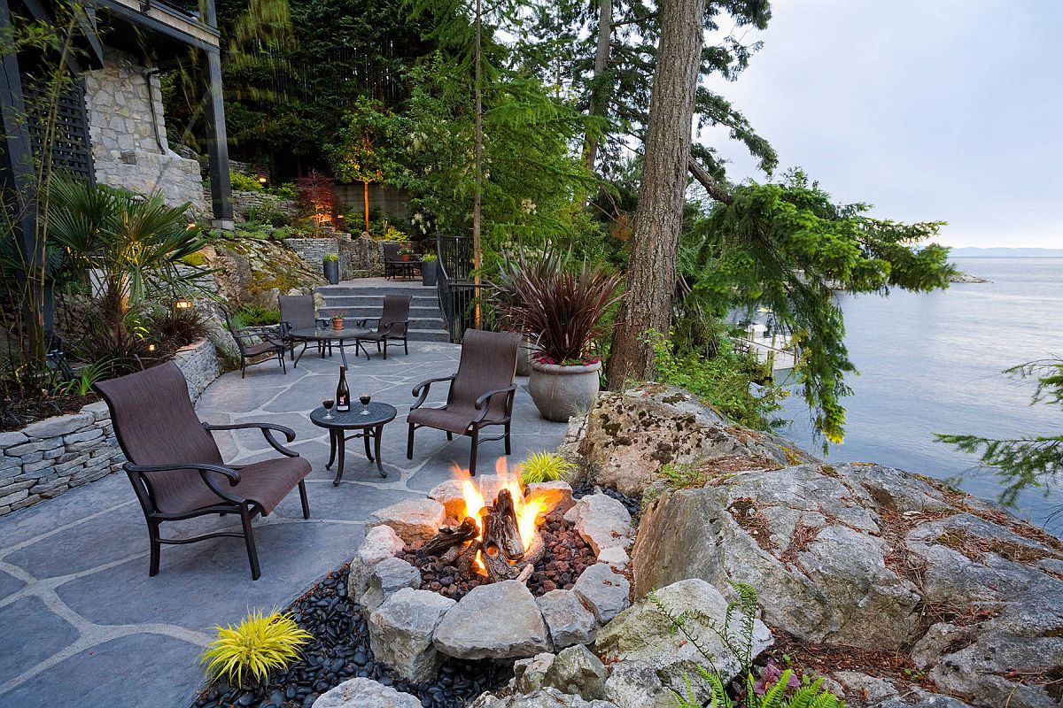 Rustic waterside terrace and backyard with fireplace and ample sitting space