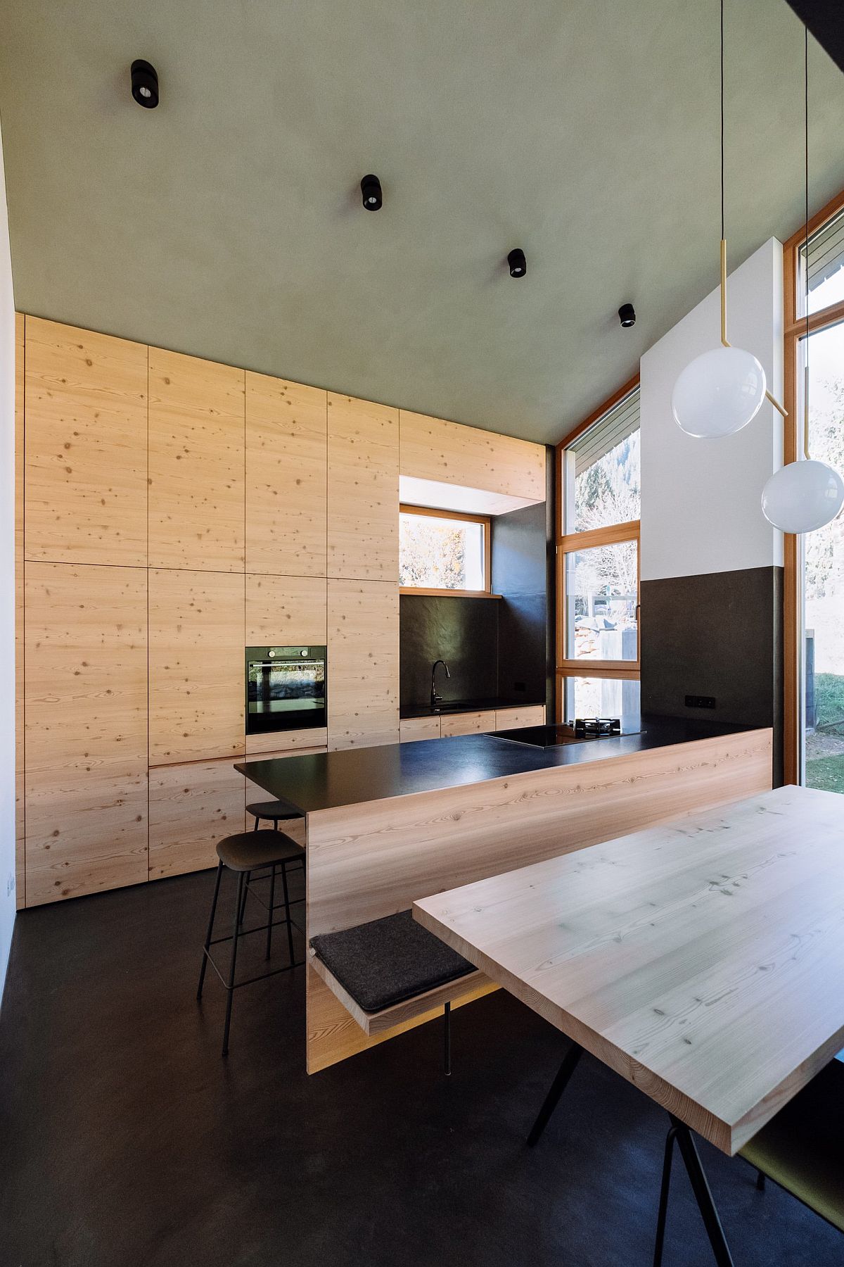 Wood and concrete modern kitchen and dining area with polished stone floors