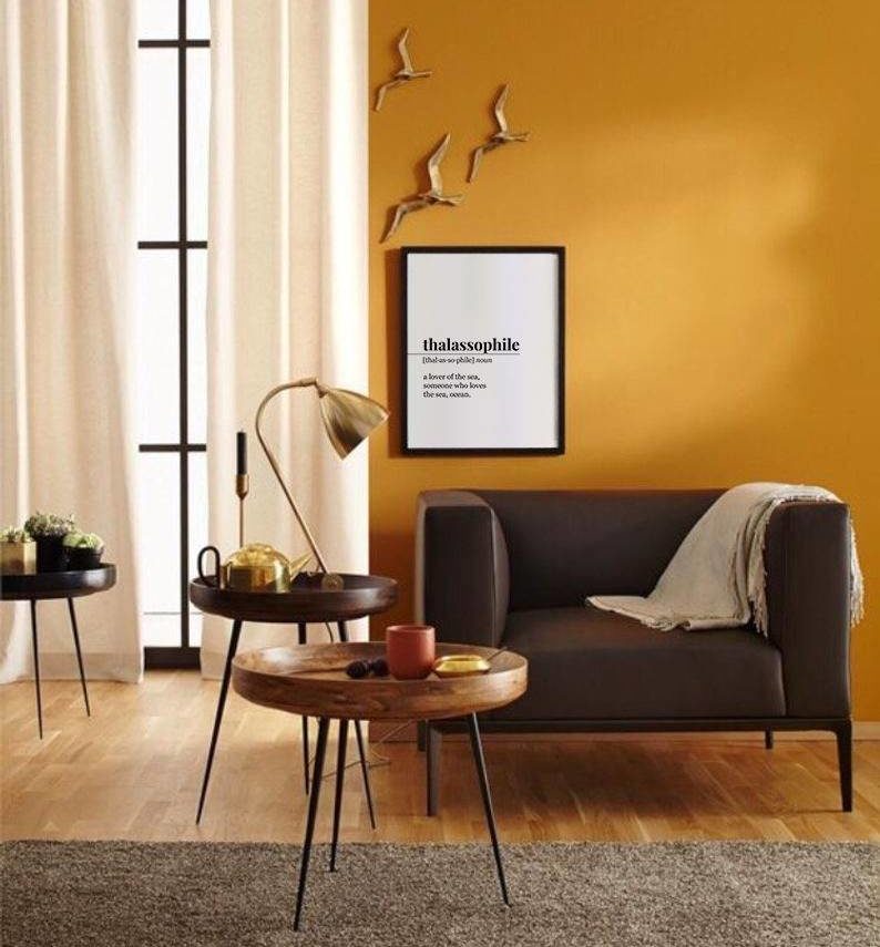 orange living room with brown furniture and wall art