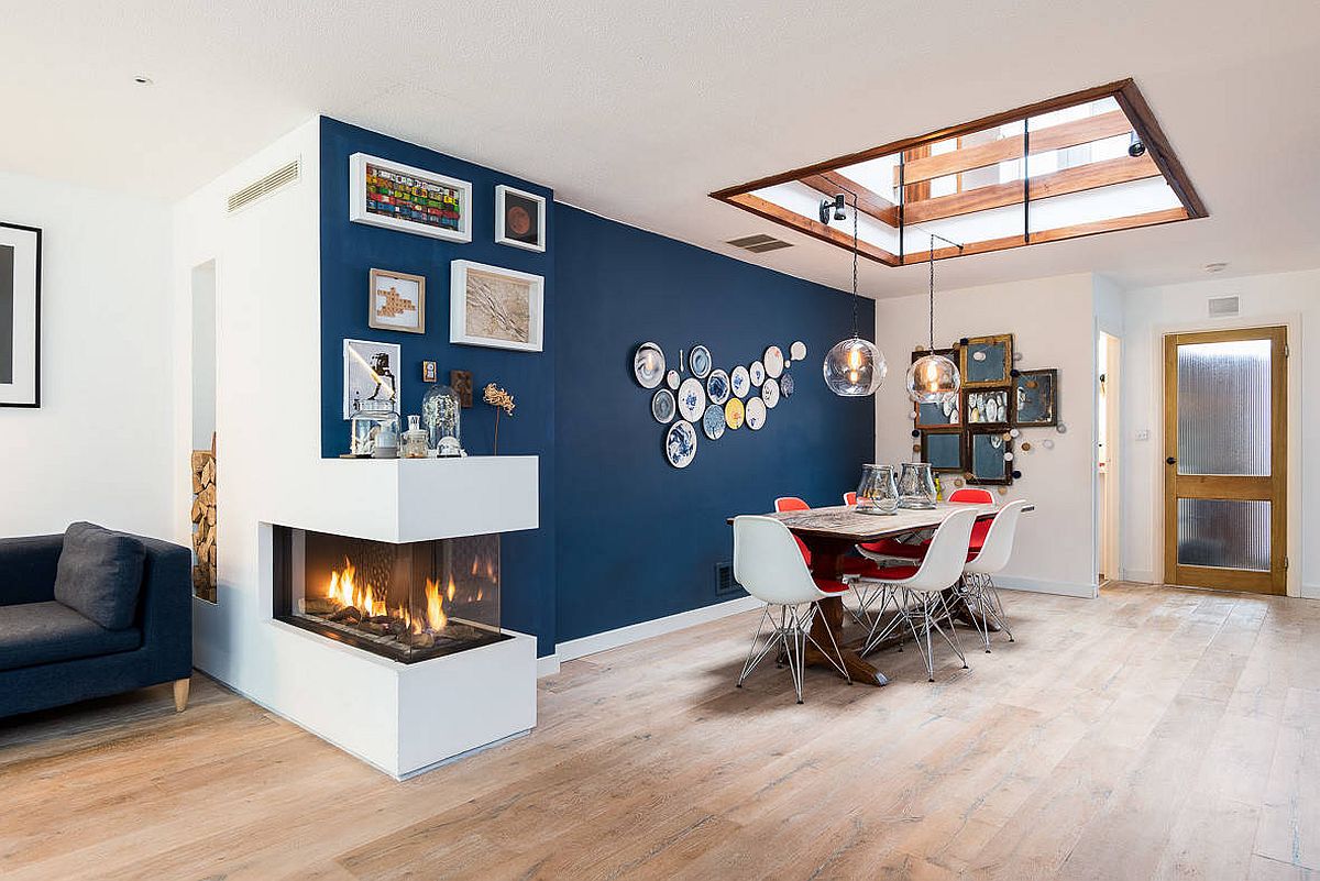 Delightful blue accent wall, skylight and a double-sided fireplace brighten this dining room