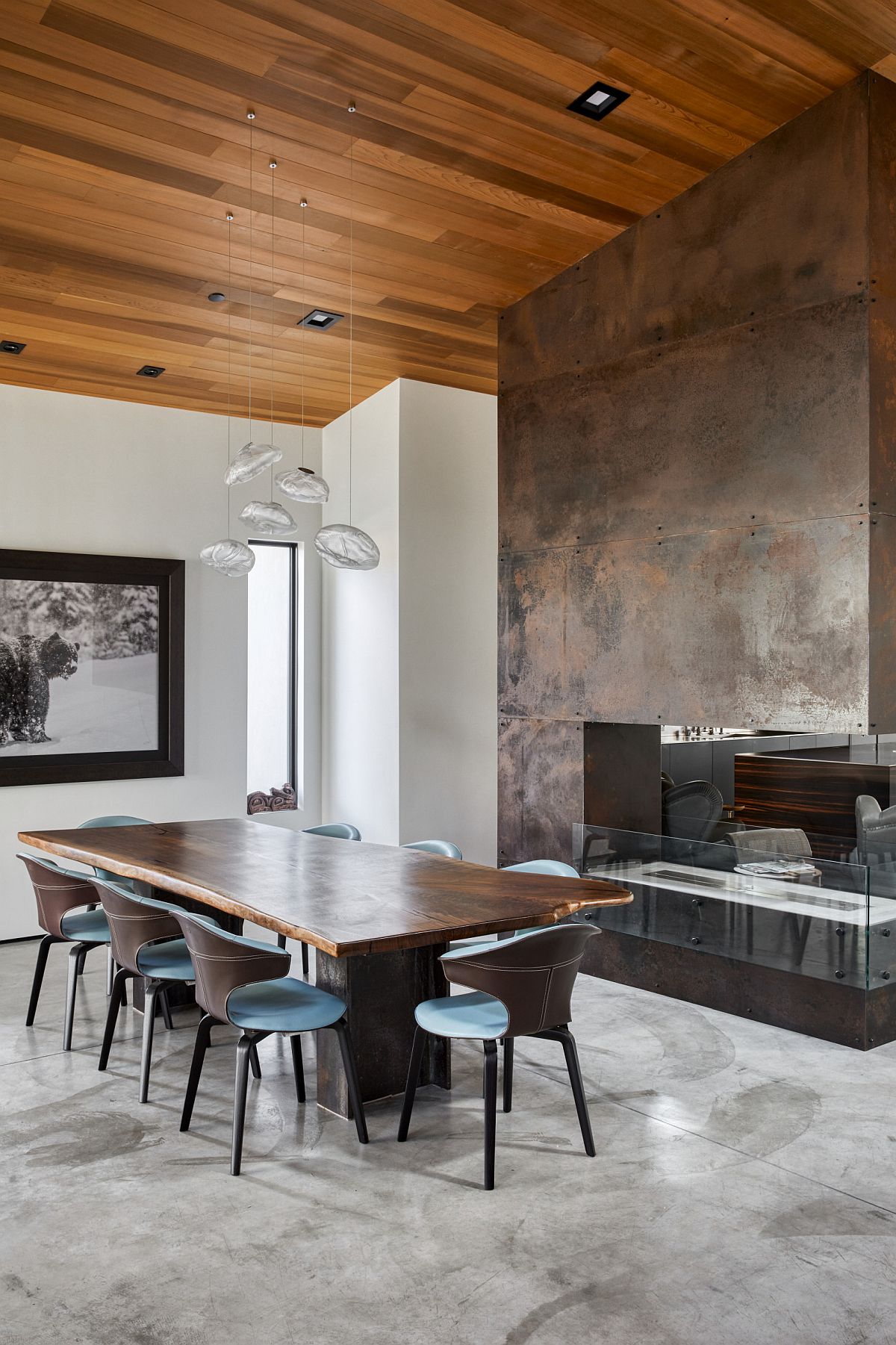 Exquisite dining room with double-sided fireplace that features a metallic wall