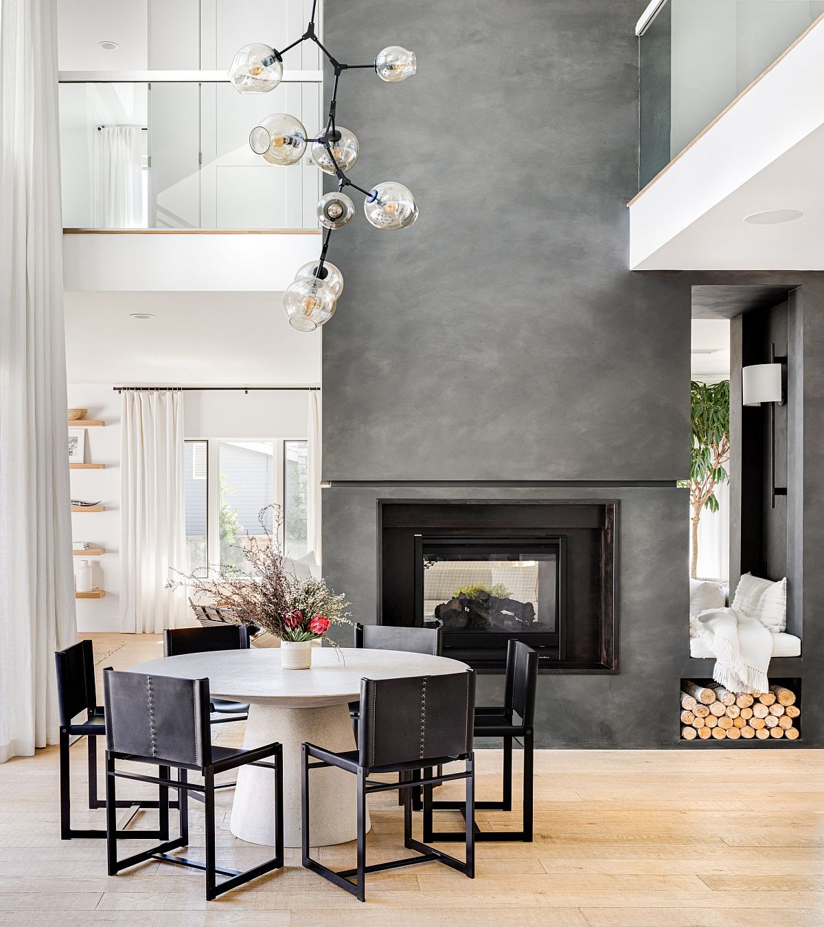 Fabulous fireplace in gray cement becomes the focal point of this amazing dining space