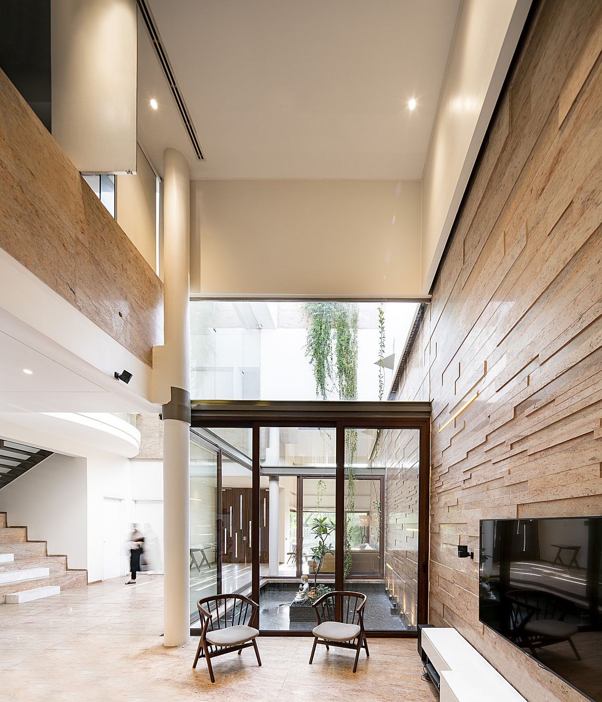 Living area and dining space on the ground floor along with a courtyard that has water feature