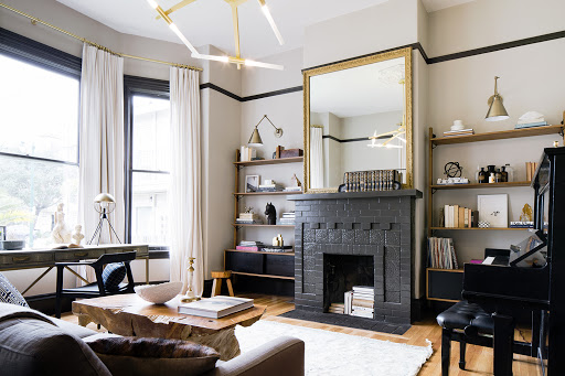 a brick fireplace painted black with mirror on mantel