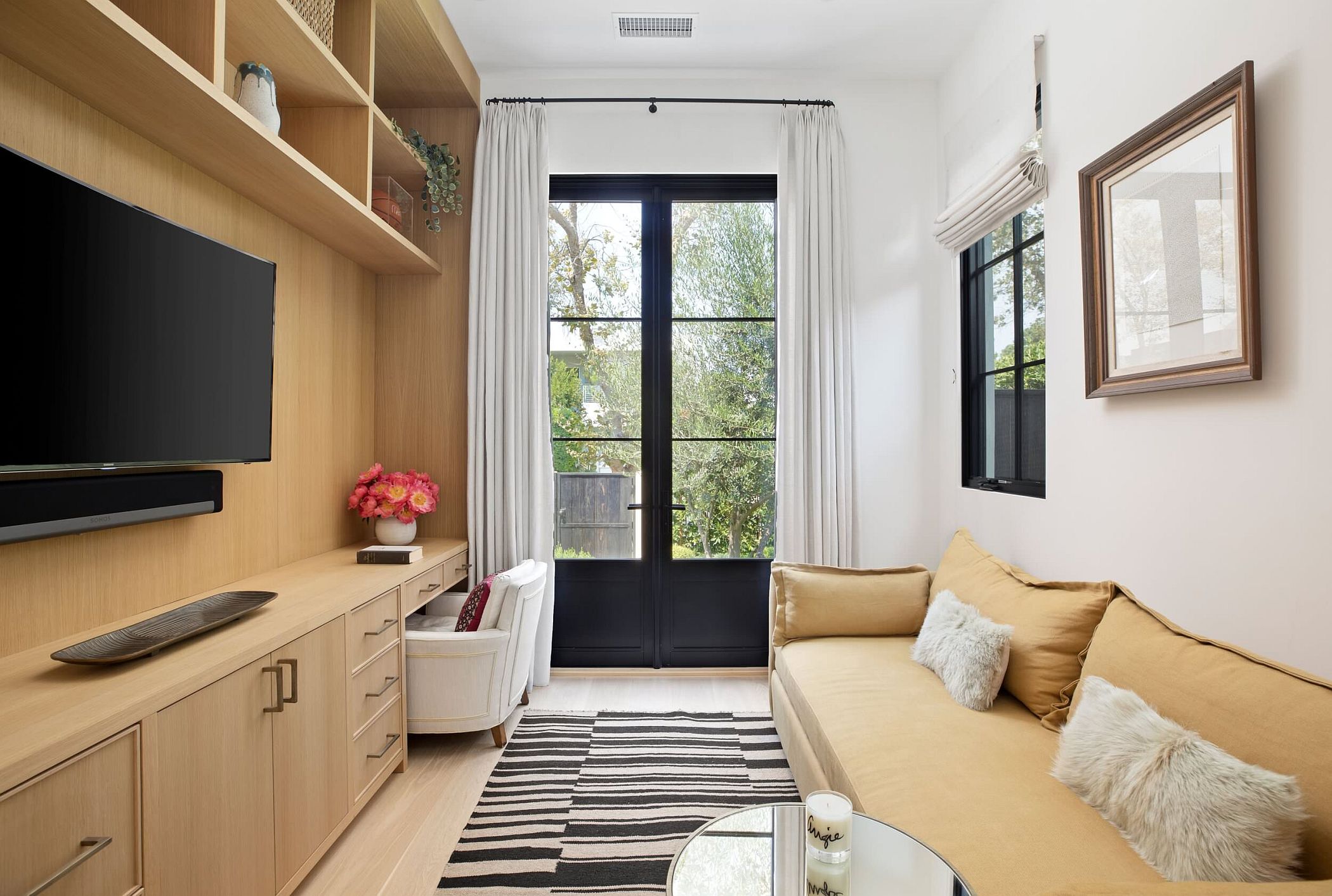 Small TV room and home office with custom wooden shelves and a comfy couch