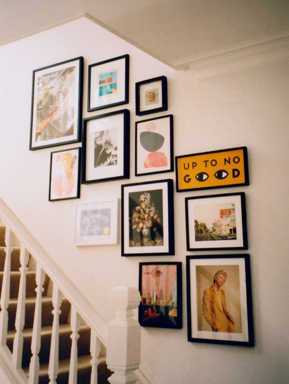colorful gallery wall display ascending up staircase